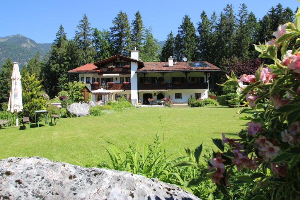 uma grande casa com um grande quintal com um grande relvado em Alpenchalet Zum Jeremia em Grainau