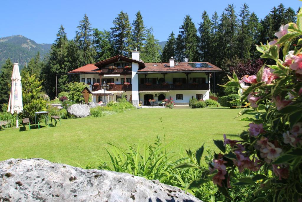 ein großes Haus mit einem großen Garten mit großem Rasen in der Unterkunft Alpenchalet Zum Jeremia in Grainau