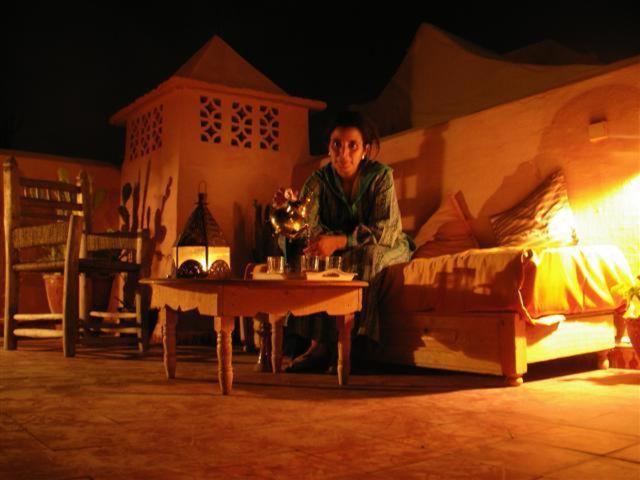 Un homme assis sur un lit à côté d'une table dans l'établissement Riad El Filali, à Marrakech