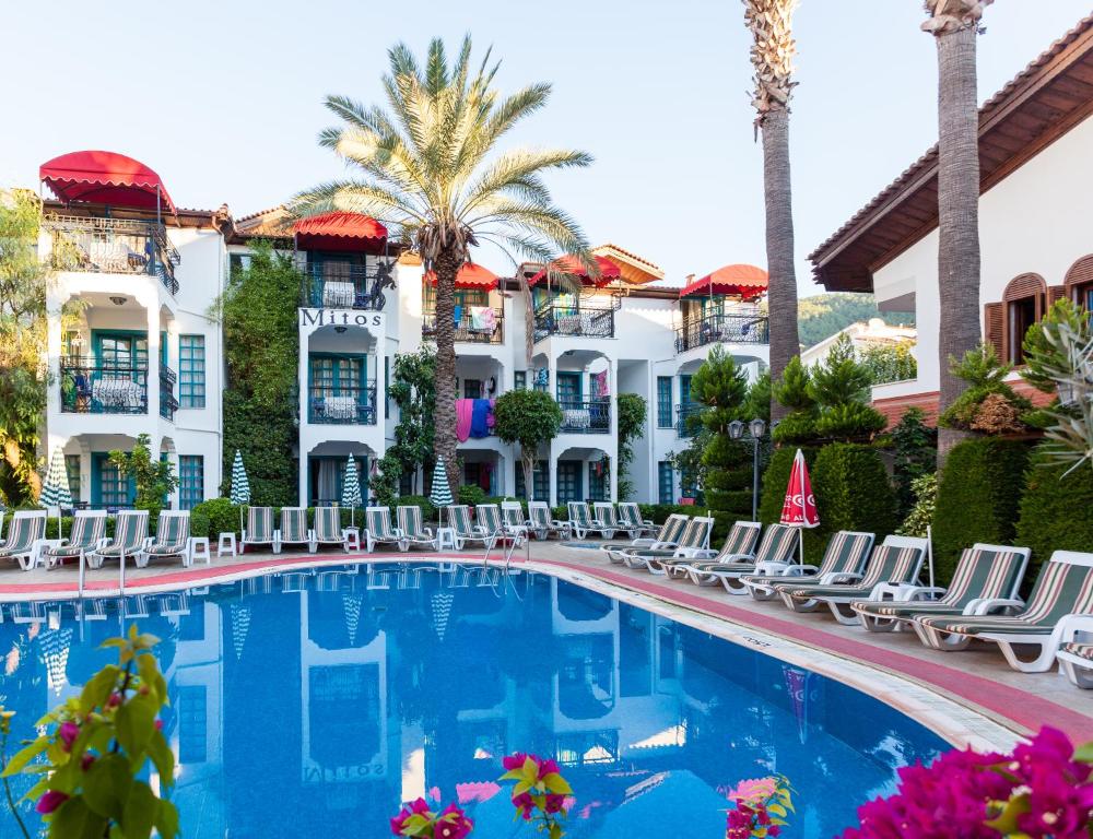 basen w hotelu z krzesłami i palmami w obiekcie Mitos Apartments w mieście Marmaris