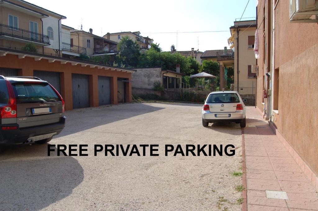 two cars parked in a parking lot with the words free private parking at Appartamenti Donato in Peschiera del Garda