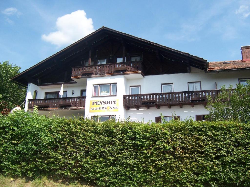a white building with a balcony on the side of it at Pension Arbersonne in Bayerisch Eisenstein