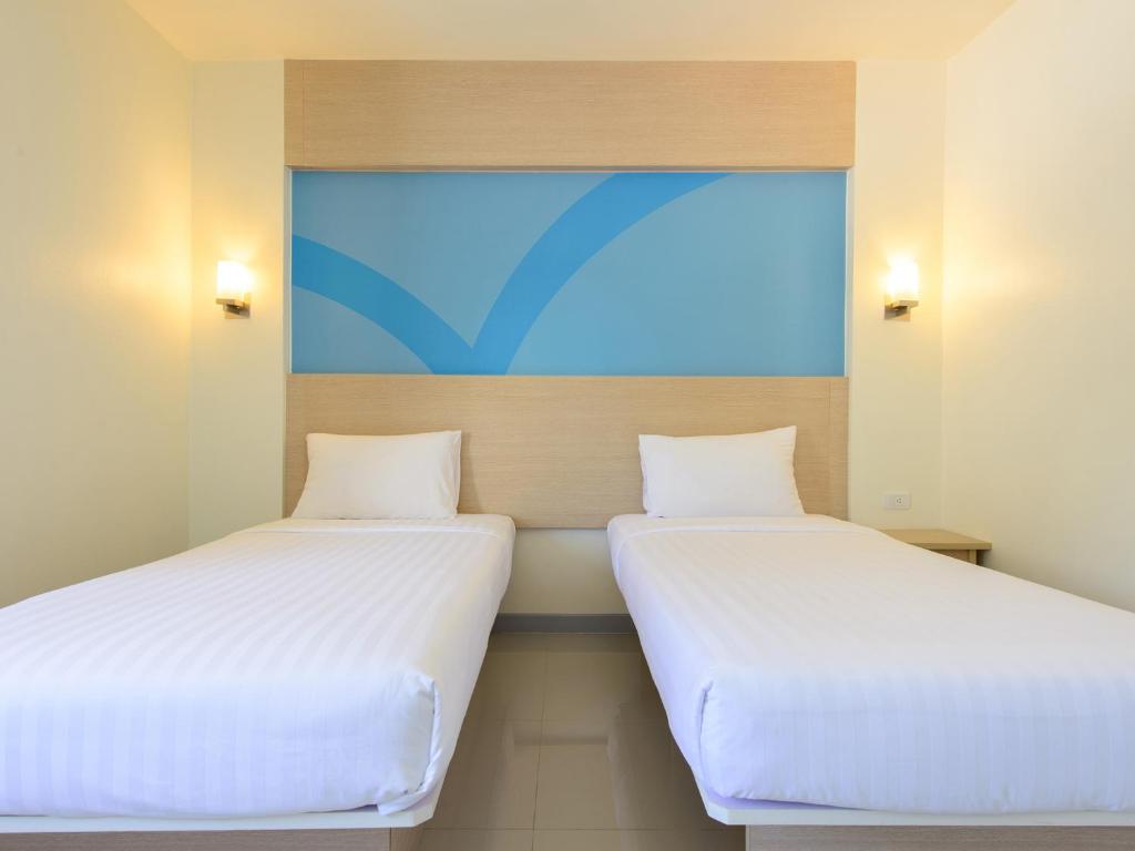 Postel nebo postele na pokoji v ubytování HOP INN Phitsanulok