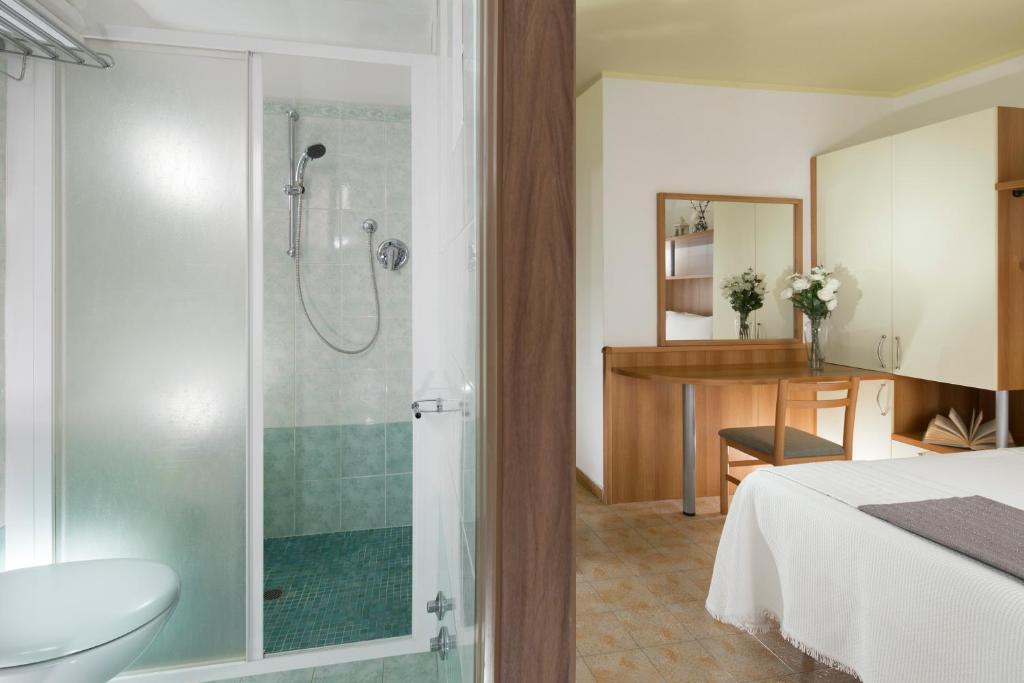 łazienka z prysznicem, łóżkiem i umywalką w obiekcie Hotel Buona fortuna w mieście Bellaria-Igea Marina