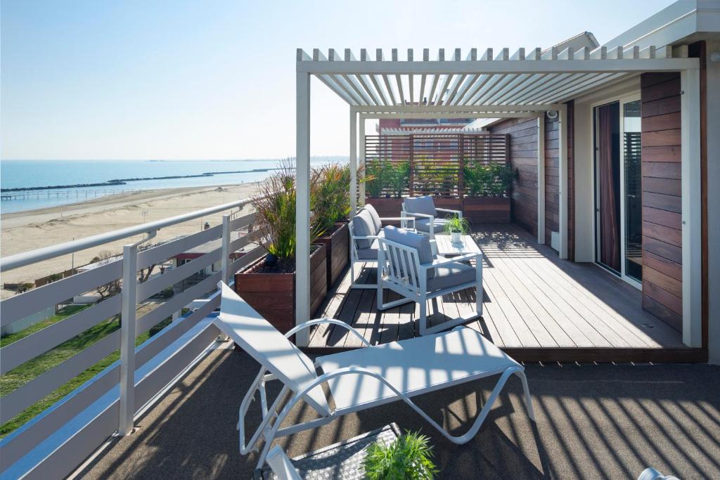 a porch with a table and chairs on the beach at Hotel LaMorosa in Rimini