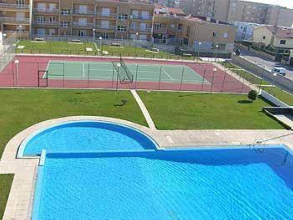 une grande piscine bleue avec un court de tennis dans l'établissement Apartment Labruge, à Praia de Angeiras