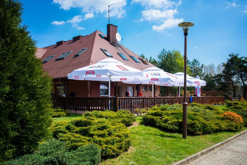 budynek z białymi parasolami w ogrodzie w obiekcie Gościniec Jurajski w mieście Kroczyce