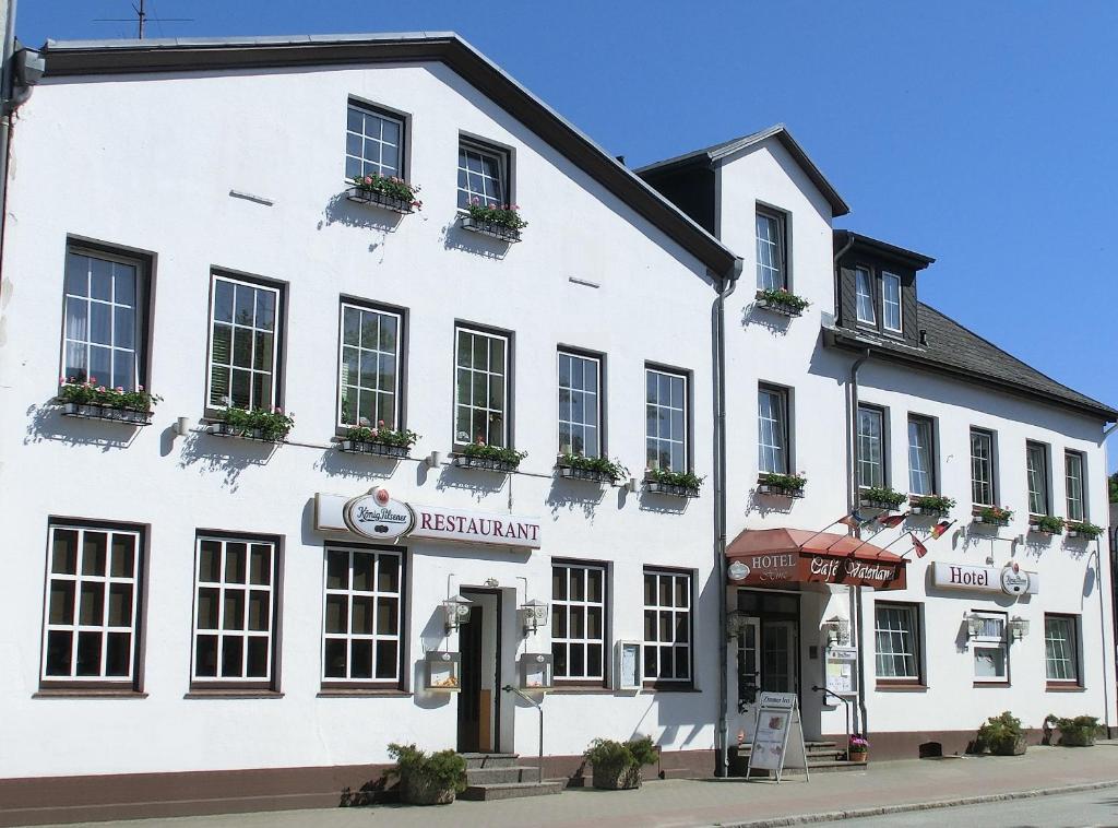 a white building with plants on the windows at Hotel Hinz in Bad Oldesloe