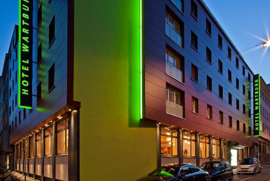 een kleurrijk gebouw met auto's geparkeerd voor het bij Hotel Wartburg in Stuttgart