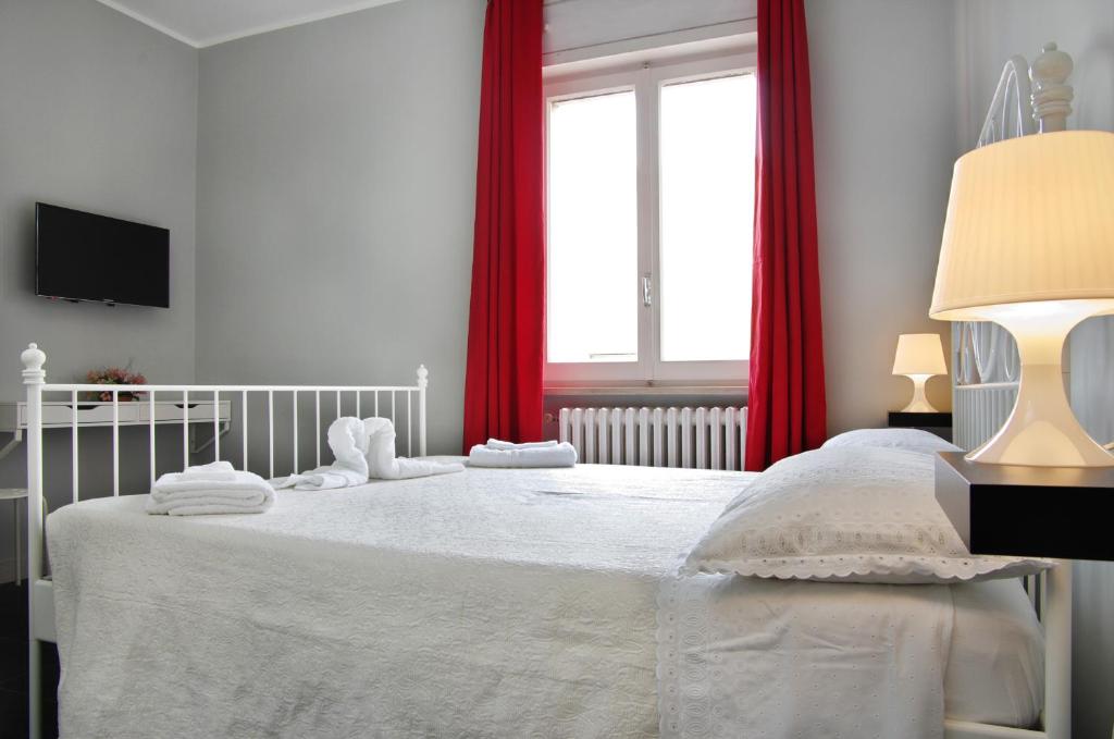 ターラントにあるB&B Binario Unoのベッドルーム(赤いカーテン付きの白い大型ベッド1台付)