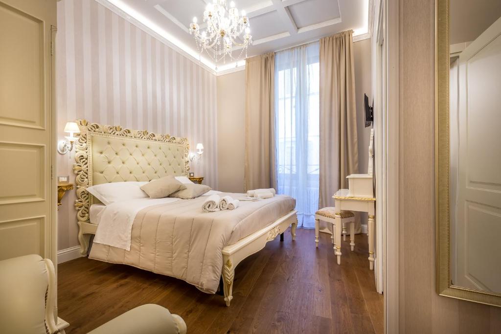 1 dormitorio con cama blanca y lámpara de araña en Relais Twelve B&B en Florencia