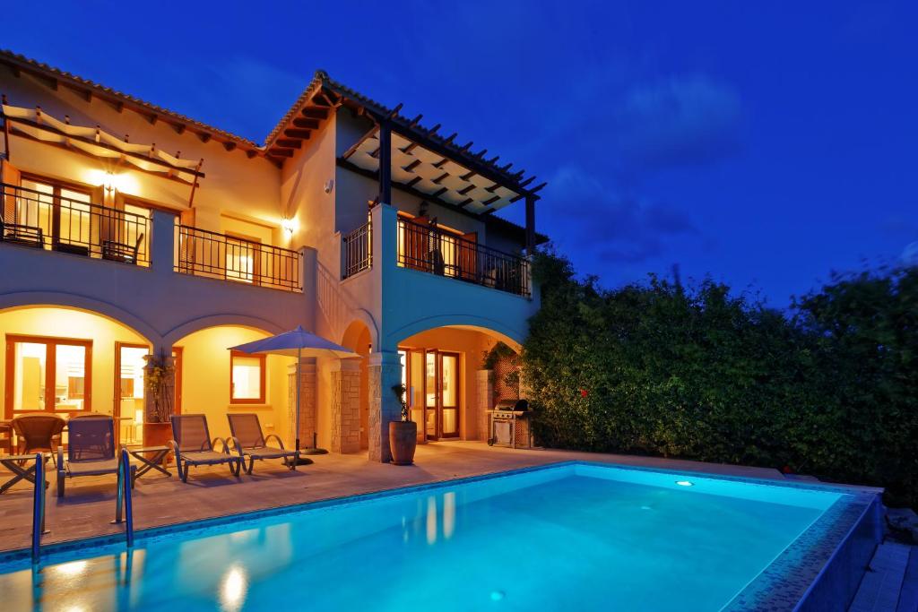 a villa with a swimming pool at night at 2 bedroom Villa Iremos with private pool and sea views, Aphrodite Hills Resort in Kouklia
