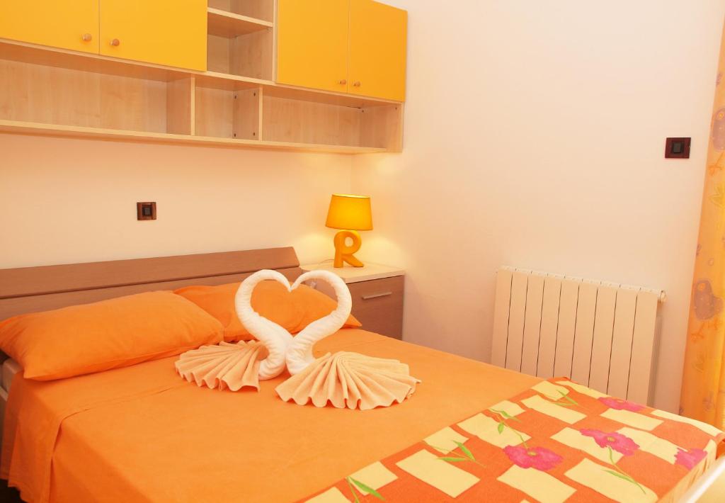 a bedroom with a bed with two swans forming a heart at Apartments Medulin - Orijeta in Medulin