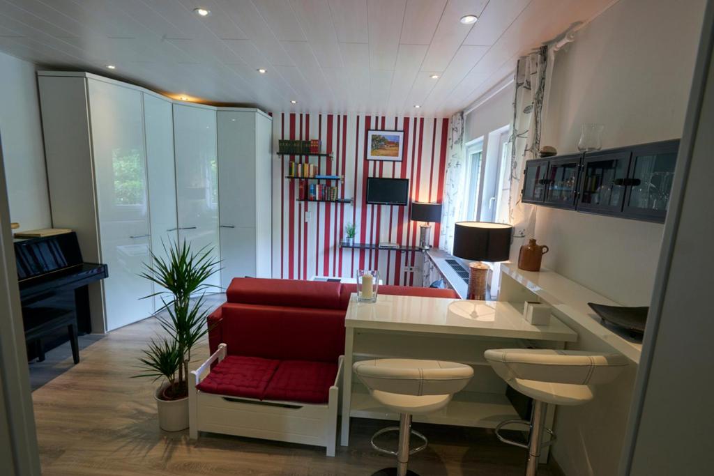 sala de estar con sofá rojo y escritorio en Ittertal Apartment, en Solingen