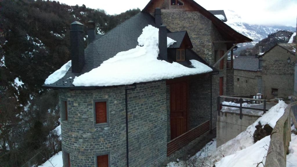 a building with snow on the roof of it at Duplex Calle El Tillo in Escarrilla