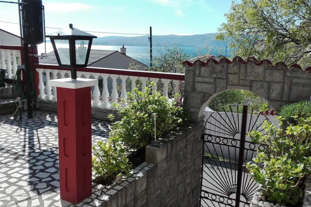 塞尼的住宿－Apartment Dunja，花园中的一个红色柱子,有栅栏