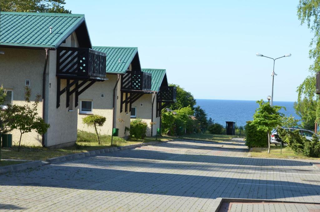 eine Straße mit Häusern und dem Meer im Hintergrund in der Unterkunft Róża Wiatrów in Władysławowo