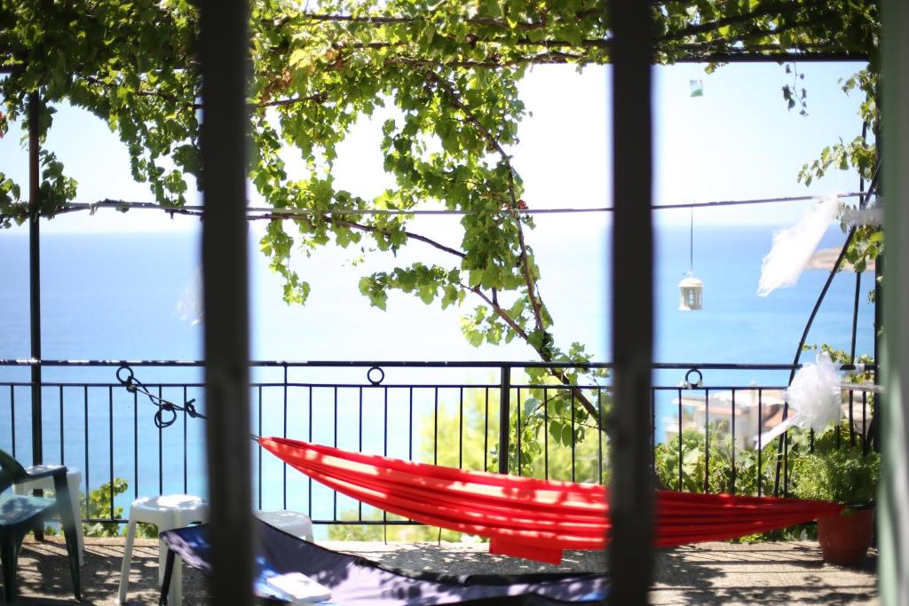 a red hammock on a balcony with a view at Valentina Rooms in Qeparo