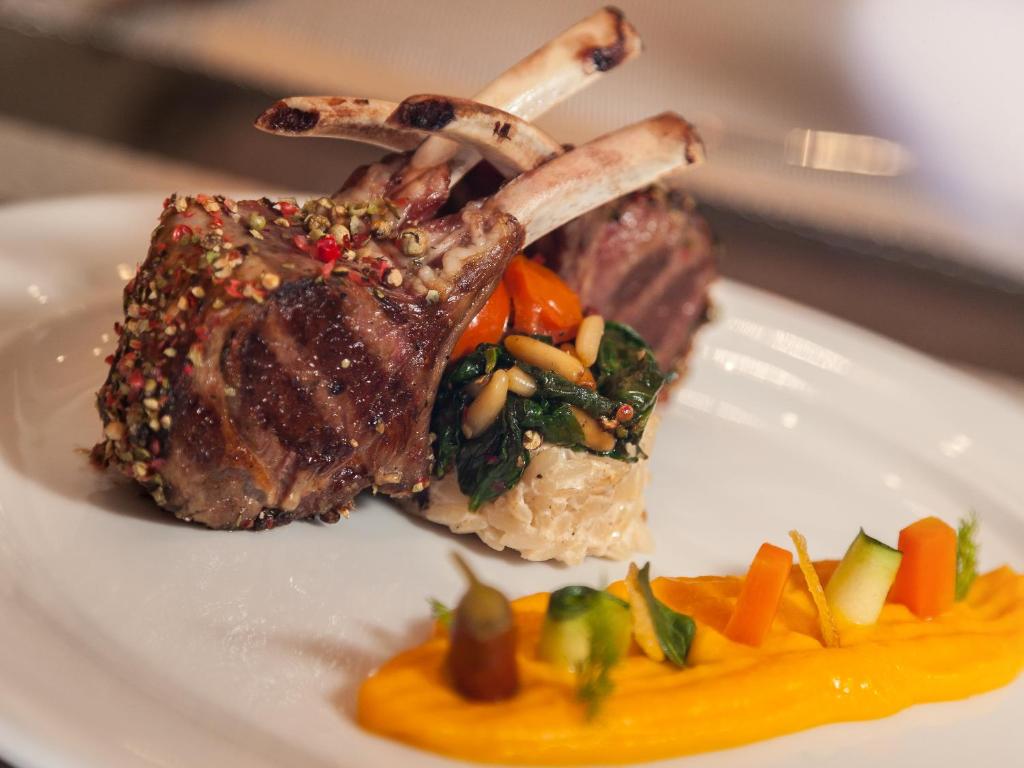 a plate of food with a piece of meat and vegetables at Continental Forum Sibiu in Sibiu