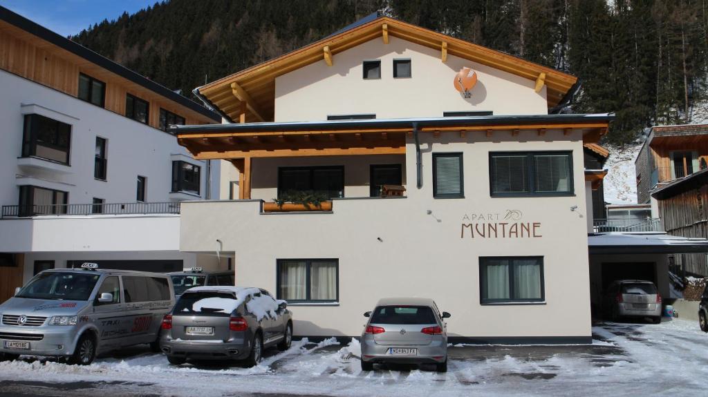 a building with cars parked in front of it at Apart Muntane in Ischgl