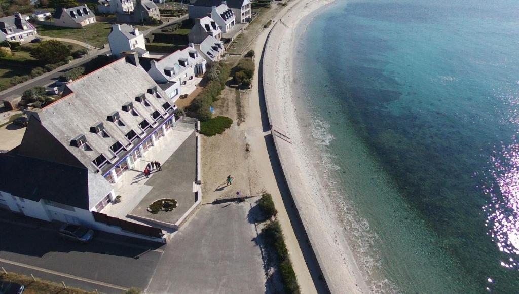 - une vue aérienne sur une plage avec des maisons et l'océan dans l'établissement Le Sterenn, à Saint-Guénolé