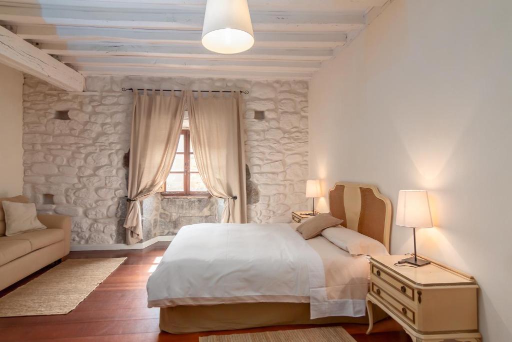 a bedroom with a bed and a couch and a window at Casona Valle de Soba in Regules