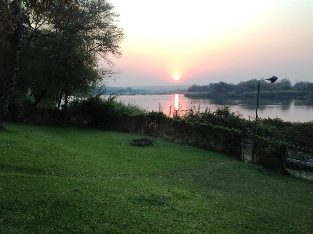 a view of a river with the sunset in the background at Sundowner Lodge in Hwange