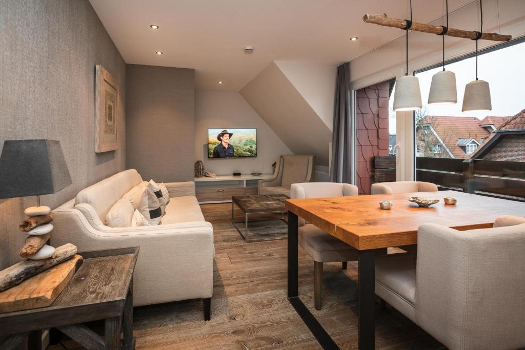 een woonkamer met een tafel en een eetkamer bij Landhaus Sylter Hahn in Westerland