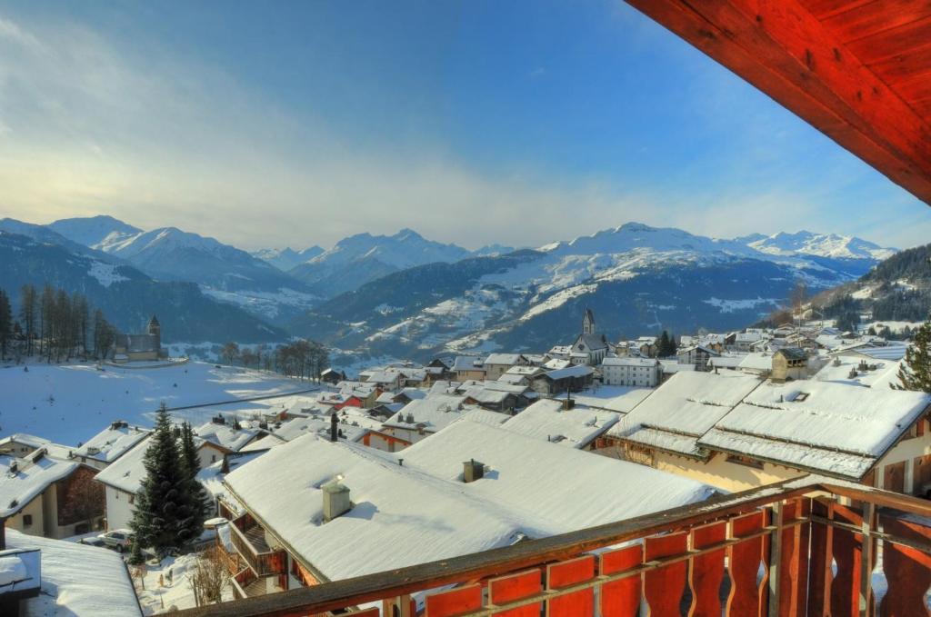 a town covered in snow with mountains in the background at Casa Ansiel - 2.5 Zimmer Ferienwohnung am Sonnenhang von Falera in Falera