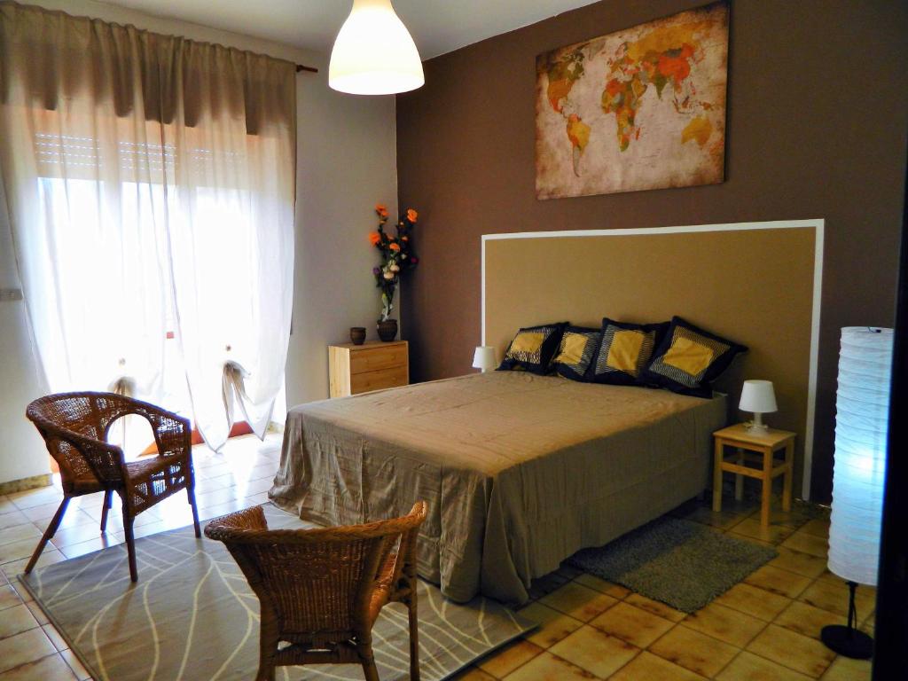 1 dormitorio con cama, sillas y ventana en Casa Relax Mare Trebisacce en Trebisacce