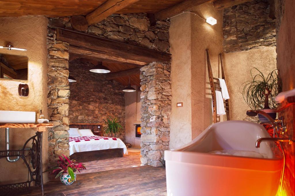 een badkamer met een bad en een bed in een kamer bij Al Mason in Frassinetto