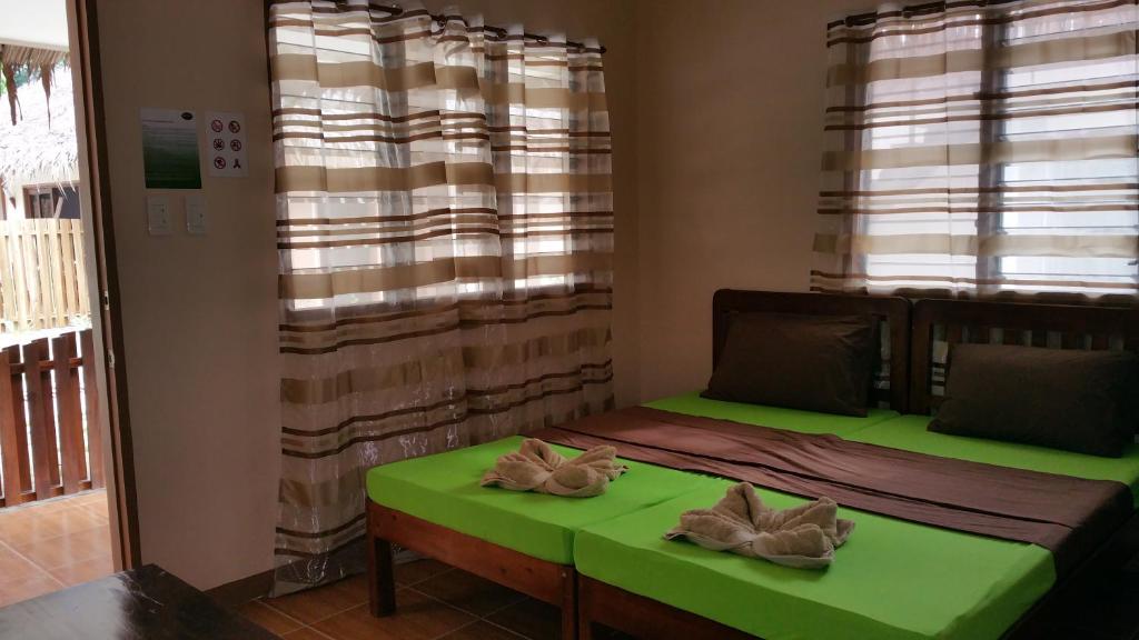 una camera con un letto verde e una finestra di Rubin Resort a San Vicente