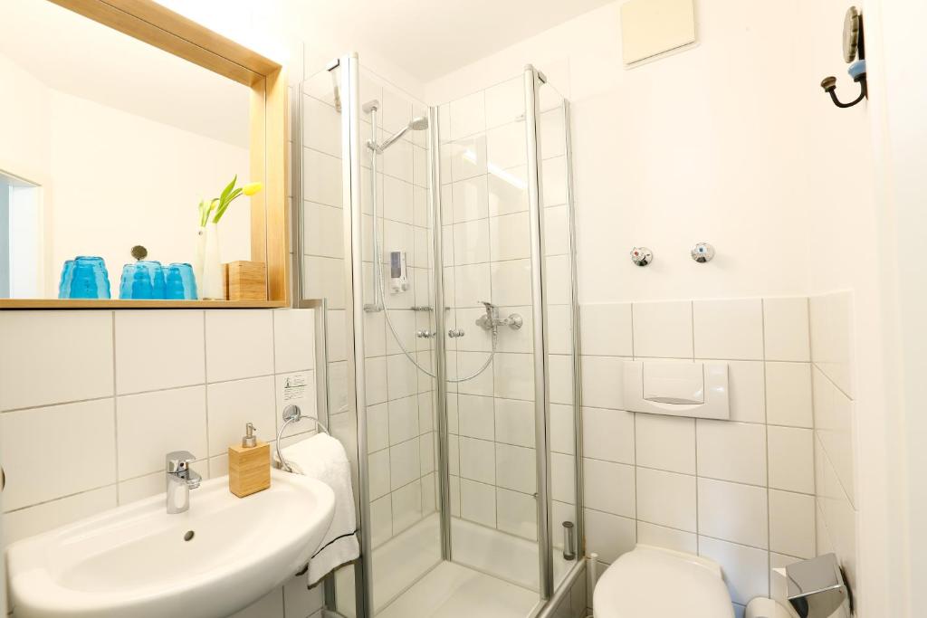 a bathroom with a shower and a sink and a toilet at Hotel am Peterstor in Regensburg
