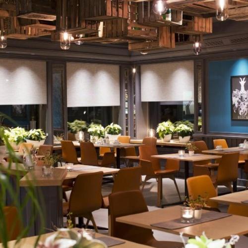 ein Esszimmer mit Tischen, Stühlen und Fenstern in der Unterkunft Hotel Buck in Bad Urach