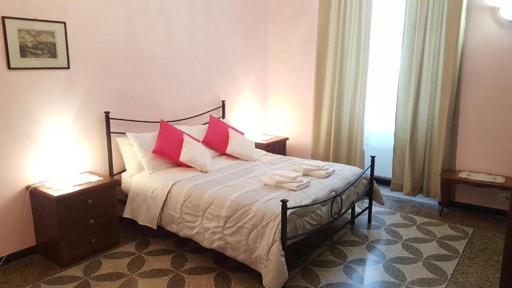 sypialnia z łóżkiem z białymi i różowymi poduszkami w obiekcie Royal Suite w Genui