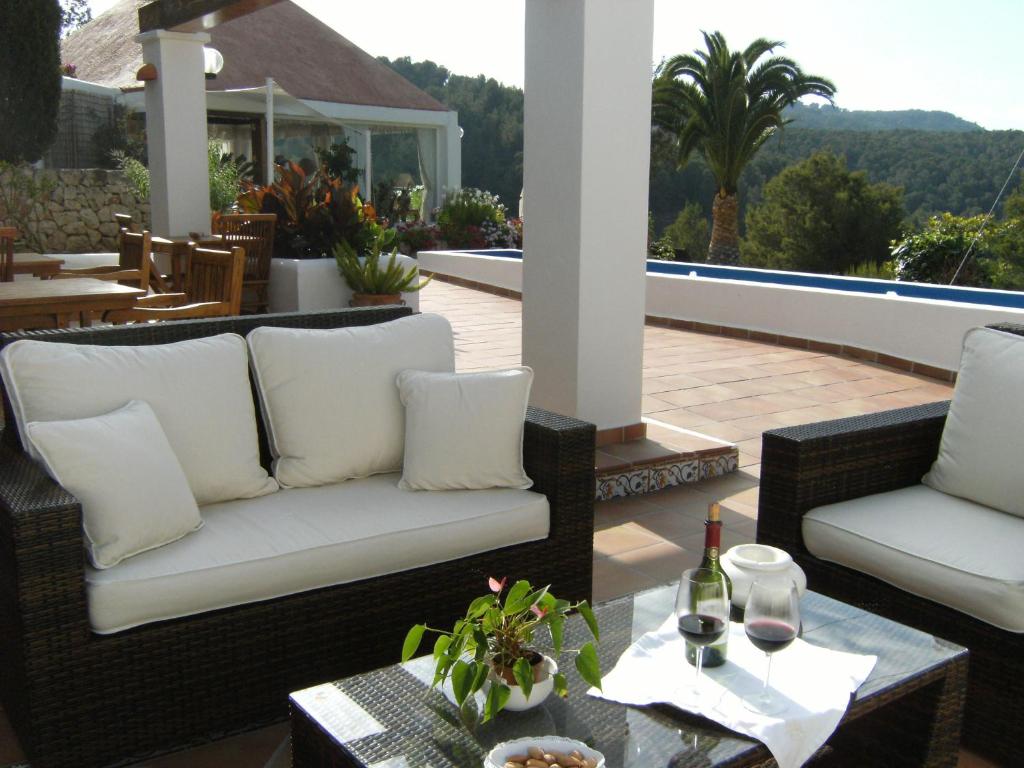 a patio with two wicker chairs and a table at Hotel Rural Can Maries in Puerto de San Miguel