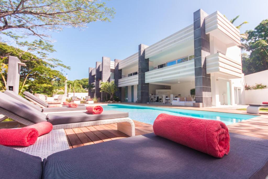 uma villa com piscina e almofadas vermelhas em CASA-22 Luxury Boutique Hotel em Sosúa