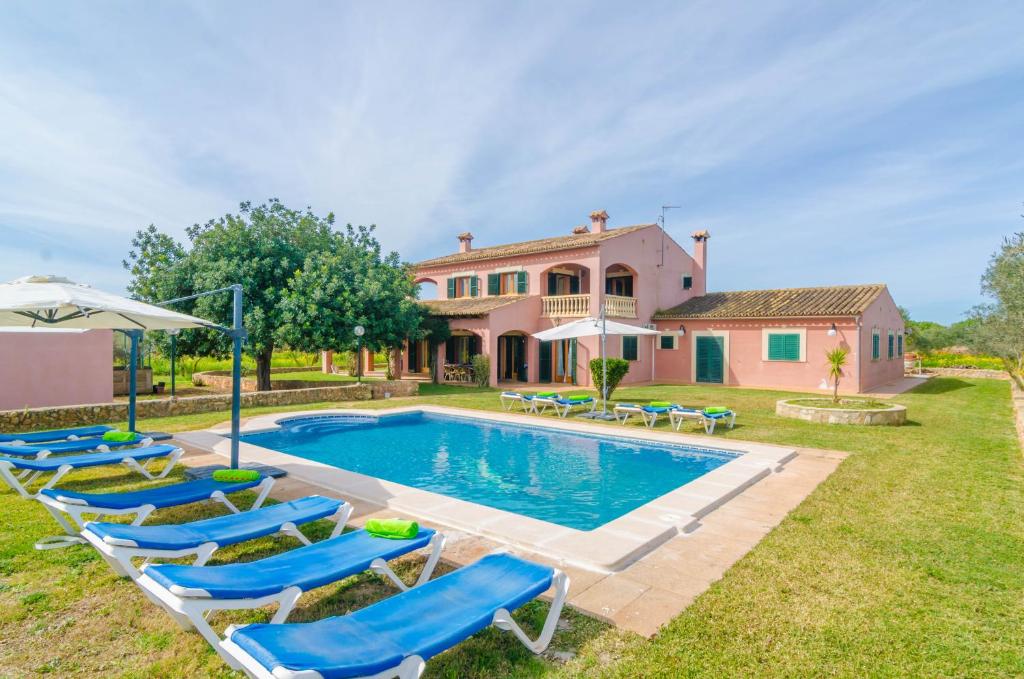a villa with a swimming pool in front of a house at Casa Campillos in Llucmajor