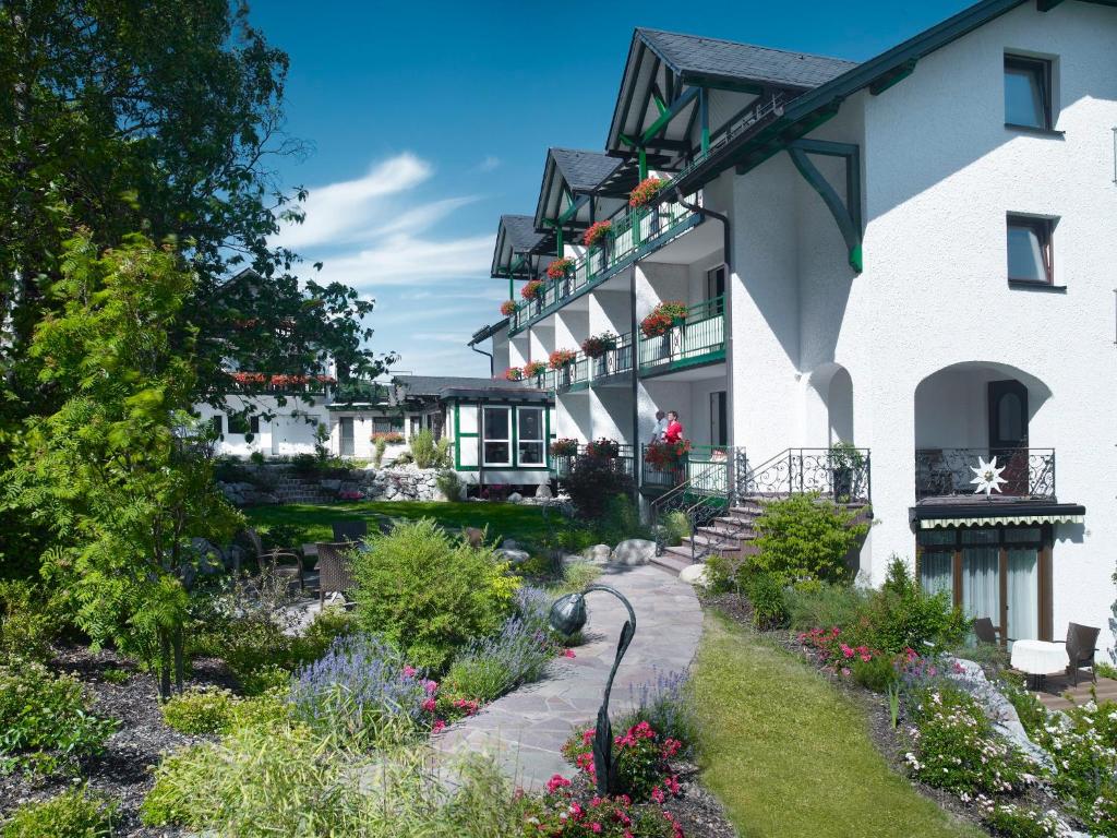 Hotel & Ferienappartements Edelweiss في فيلنغن: منزل أمامه حديقة