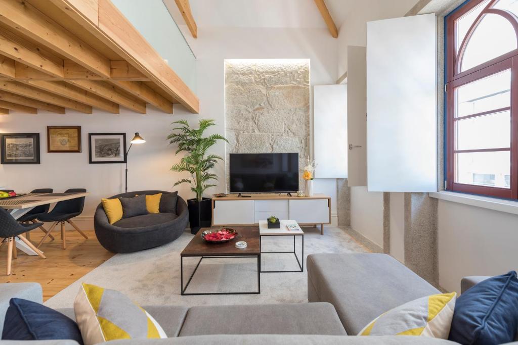 a living room with a couch and a table at LovelyStay-Modern Loft City Center in Porto