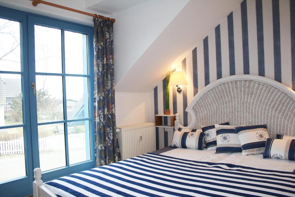 1 dormitorio con 1 cama grande con rayas azules y blancas en Ferienwohnung Urte in Putgarten , Kap Arkona Rügen, en Putgarten
