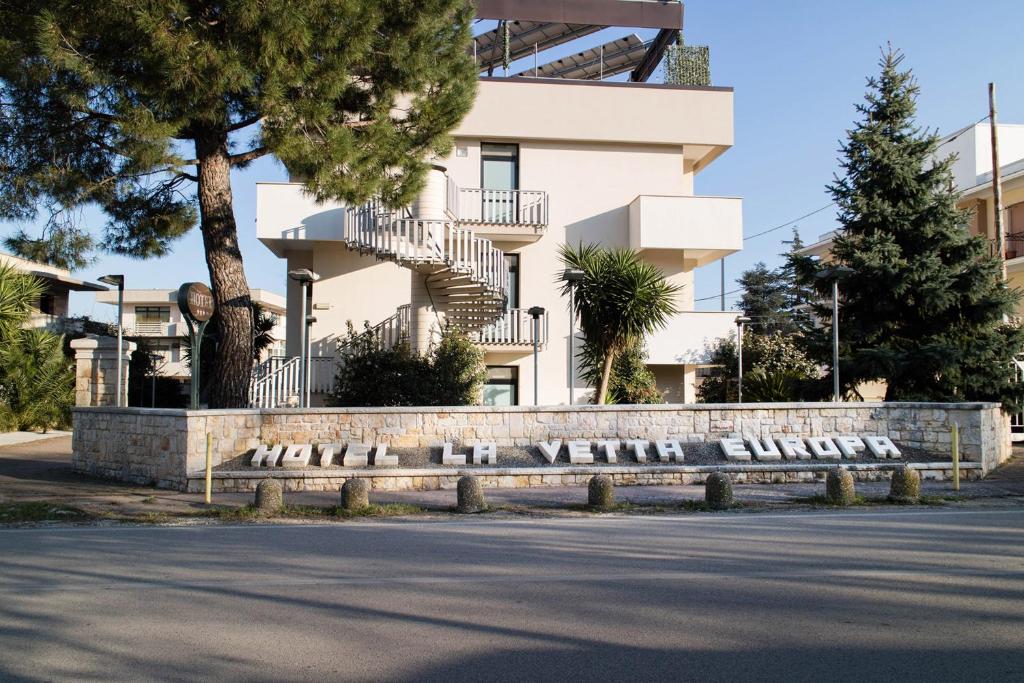 a building with a sign in front of a street at Hotel La Vetta Europa in Castellana Grotte