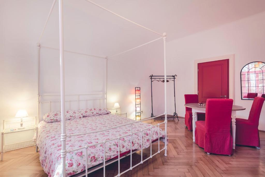 a bedroom with a canopy bed and a table and chairs at Bolzano Rooms in Bolzano