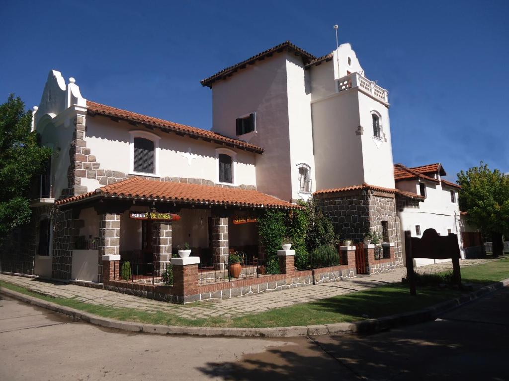 a large white building with a clock tower on a street at Hosteria Zure-Echea in Valle Hermoso