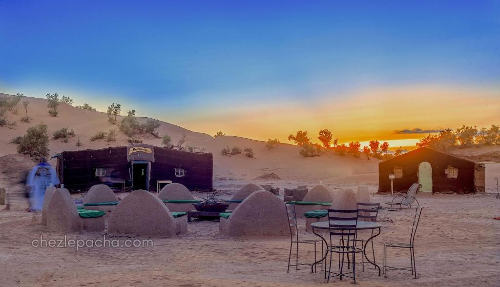 a group of chairs and tables in the desert at Bivouac M'hamid Le Pacha in Mhamid