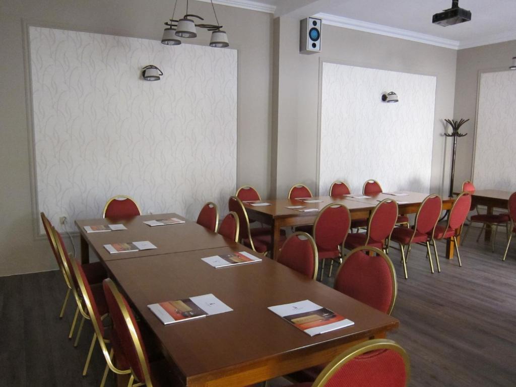 a conference room with wooden tables and red chairs at Hotel Transilvania in Cluj-Napoca