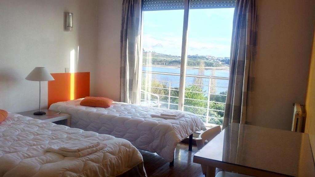 HI Porto - Pousada de Juventude في بورتو: غرفة فندقية بسريرين ونافذة كبيرة