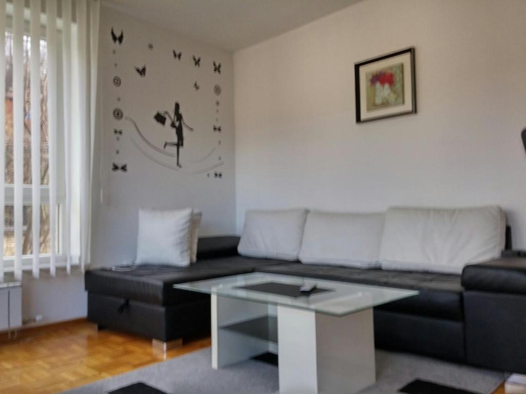ein Wohnzimmer mit einem Sofa und einem Tisch in der Unterkunft Aprtments Belma in Sarajevo