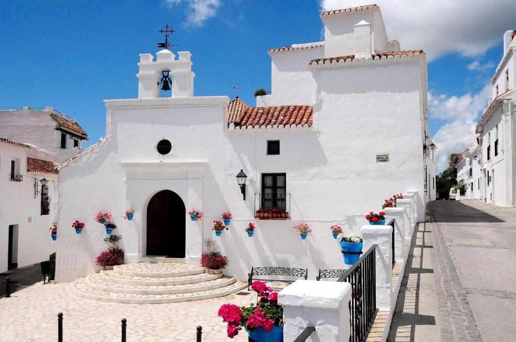 Una iglesia blanca con flores delante. en La Casa de la Iglesia en Mijas