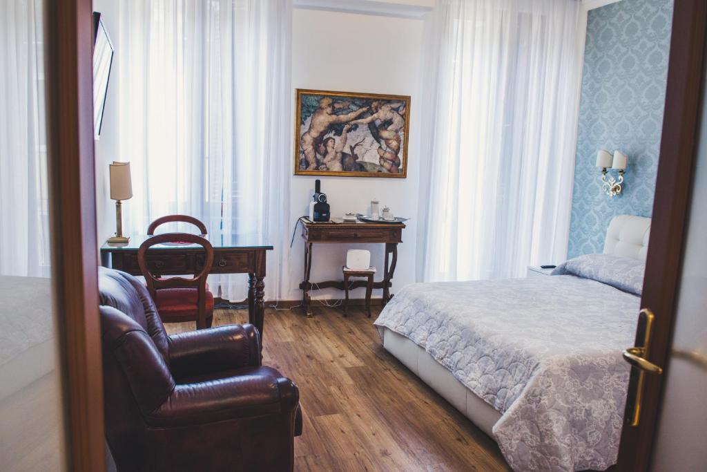 een slaapkamer met een bed, een stoel en een bureau bij Arte&Musica in Verona